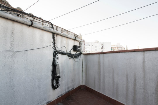 Detalle del terrado de un bloque de pisos viejo. Detalle de instalaciones el&eacute;ctricas y de cables para tender la ropa