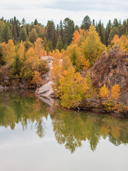 Stunning photo of fall foliage reflected on a lake with a glass like mirror water surface