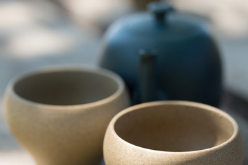Chinese tea ceremony. Ceramic teapot made of clay and bowls on a wooden background.
