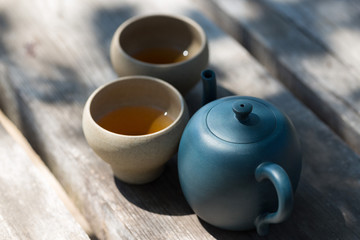 Chinese tea ceremony. Ceramic teapot made of clay and bowls on a wooden background.