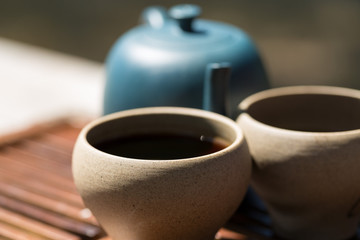 Chinese tea ceremony. Ceramic teapot made of clay and bowls on a wooden background.