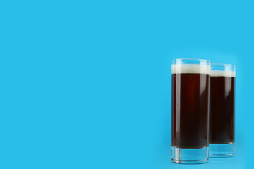 Delicious homemade kvass in glasses on light blue background. Space for text