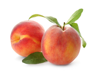 Delicious ripe juicy peaches with leaves isolated on white