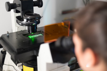Life science female researcher microscoping in scientific genetic laboratory. Healthcare and...