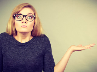 Nerdy woman in eyeglasses being confused