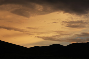 Silhouette of the hill at the orange sky background
