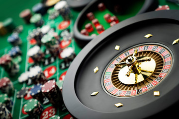 Casino theme, close up of roulette, red and black numbers. Stack of chips in the background.