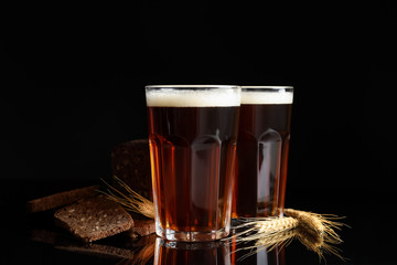 Delicious kvass, bread and spikes on black background