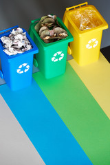 Three color coded recycle bins, isometric picture on geometric paper background with copy-space....