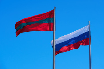 Fototapeta na wymiar the national flag of Transnistria and Russia against the sky