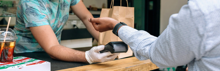 Detail of unrecognizable young man paying with smartwatch