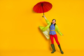 Full length photo crazy positive girl hold air wind blow fly parasol impressed rain storm weather wear blue dotted blouse trousers gumshoes isolated bright shine color background
