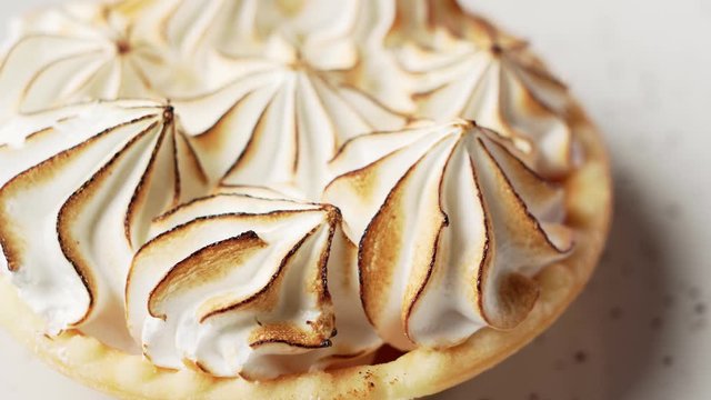 Lemon meringue tart on the black plate.