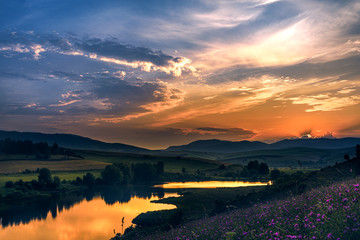 Evening landscape with hills and lake, sky with clouds. Russia, Altai territory