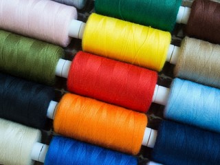 Threads of different colors on spools, regularly arranged in slantig rows