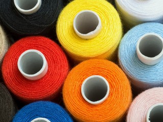 Threads of different colors on spools, standing vertically,top view,detail