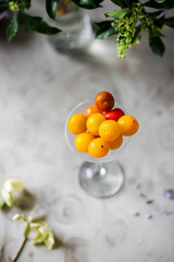 Small cherry tomatoes in a glass. Red and yellow vegetables.