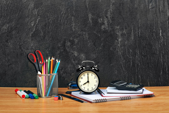 Stationery on wooden table on a gray background, closeup. Copy space.
