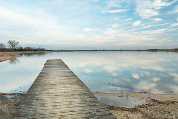 Empty wooden platform towards the lake, horizon and sky, Staw, Poland