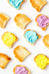 Pattern of toast bread with colored cheese spread. Layout top view