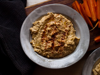 Chickpea hummus home made in natural light on farm table.