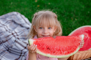 portrait of a girl holding a watermelon in her hands smiling in the Park
