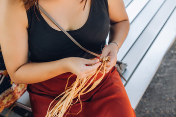 Female weaving basket on the craft workshop. Hands holding the craftwork, close up shot.