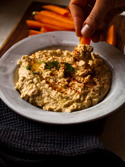 Chickpea hummus home made in natural light on farm table.