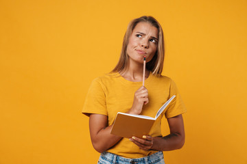 Image of young brooding woman thinking and holding exercise book