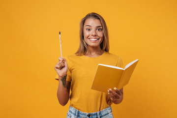 Image of young excited woman smiling and holding exercise book