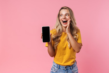Surprised young woman showing display of mobile phone
