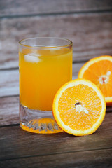 yellow drink in a glass and slices of natural orange