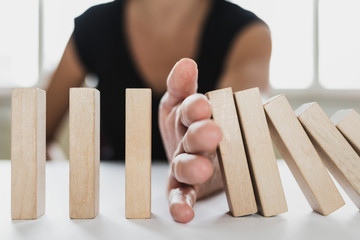 Business mediator stopping falling wooden dominos with hand dispute settlement mediation consultant advisor solving conflicts problems - obrazy, fototapety, plakaty