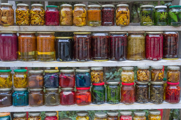 Fototapeta na wymiar lot of glass jars of different sizes with preservation after harvesting fruits, vegetables, berries, mushrooms. Jam, pickles in jars