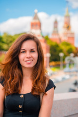 Portrait of a beautiful young female tourist with a view of the Kremlin in Moscow, Russia