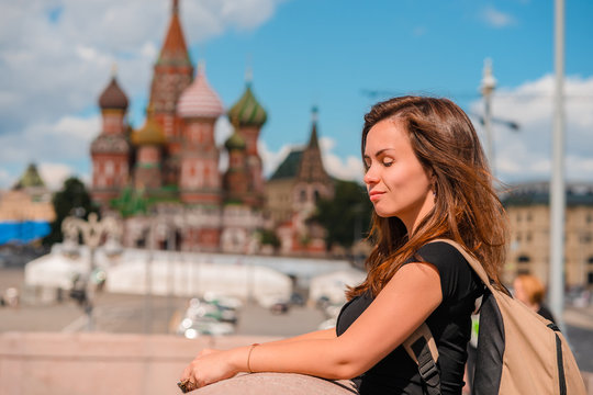 Portrait of a beautiful young female tourist with a view of the Kremlin in Moscow, Russia