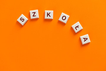 Napis szkoła na pomarańczowym tle z dodatkami © andsko