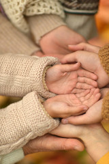 Cropped image, family putting hands together close up 