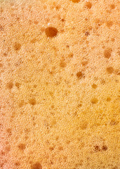 an orange dishwashing sponge with visible details. background