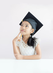 Portrait little Asian girl is wearing graduate hat and smile with happiness select focus shallow depth of field with copy space for education concept