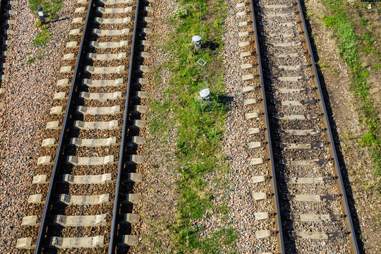 Pair of parallel railway tracks. Space between them filled with gravel & grass