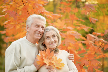 Beautiful happy senior couple with autumn leaves