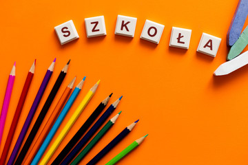 Napis szkoła na pomarańczowym tle z dodatkami © andsko