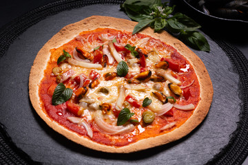 Food concept Homemade Tortilla Seafood pizza on black slate stone plate on black background with copy space