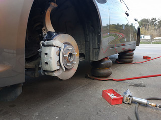 Tire. Seasonal change of car tires. Car without a wheel on a jack