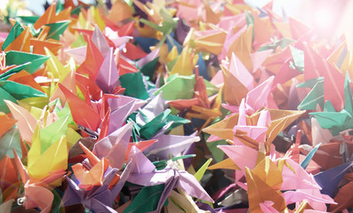 Origami bird papers are fold for peace and freedom. Colorful bird papers. Toned Vintage, Concept and Illuminated background.