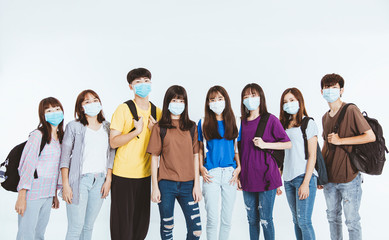 young student group wearing protective medical face masks standing together