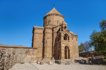Obraz premium Main facade of medieval Armenian Cathedral of Holy Cross & empty square in front of it, Akdamar island, Van Lake, Gevaş, Turkey. Built in 921, it's still masterpiece among many christian churches