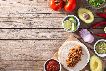 Mexican tacos ingredients on wooden table. Top view.Copy space
