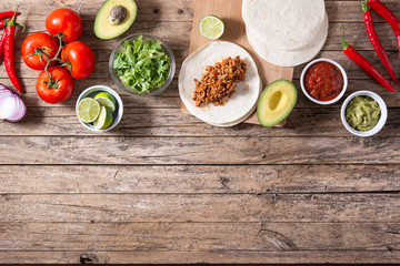 Mexican tacos ingredients on wooden table. Top view.Copy space